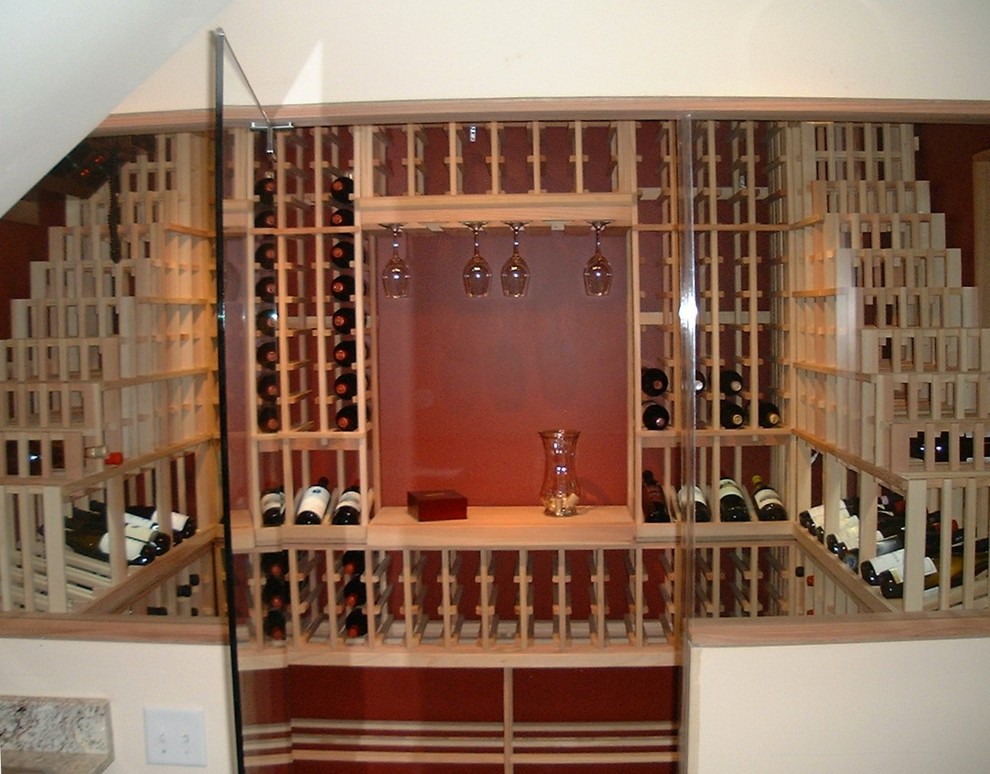 На фото: винный погреб среднего размера в классическом стиле с стеллажами