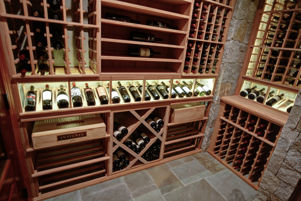 Exemple d'une grande cave à vin chic avec un sol en travertin et des casiers.