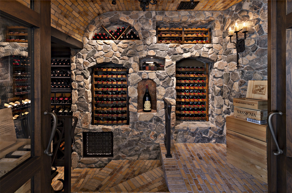 Cette photo montre une grande cave à vin méditerranéenne avec un sol en brique, des casiers et un sol multicolore.