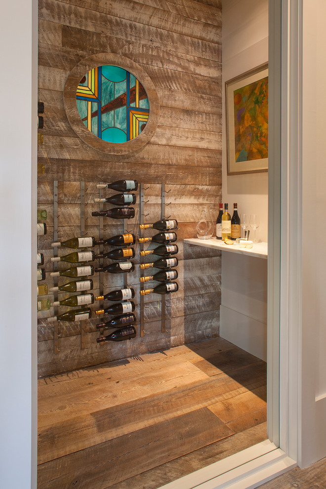 Wine cellar - coastal painted wood floor and brown floor wine cellar idea in Other with storage racks