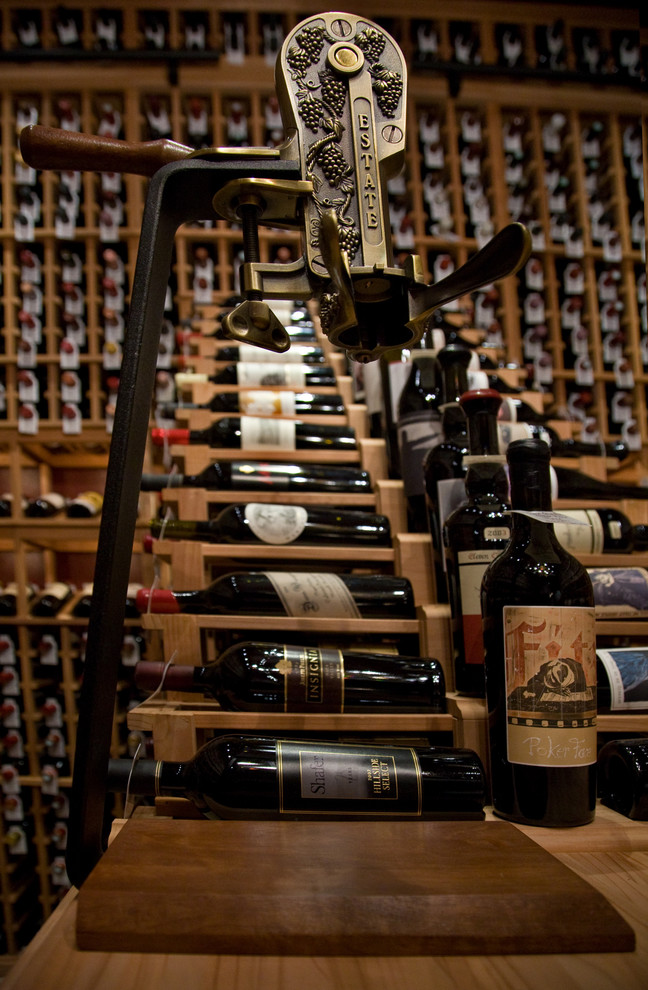 Bild på en stor vintage vinkällare, med vinhyllor, kalkstensgolv och beiget golv