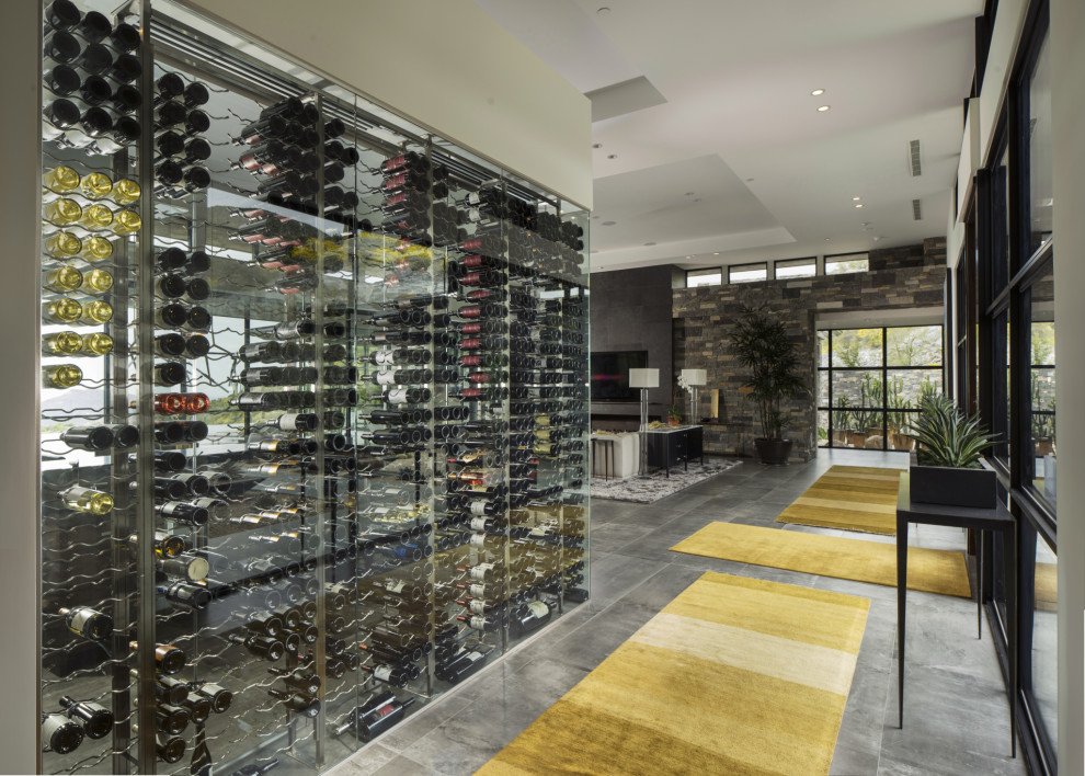 Bild på en mellanstor funkis vinkällare, med vinhyllor, betonggolv och grått golv