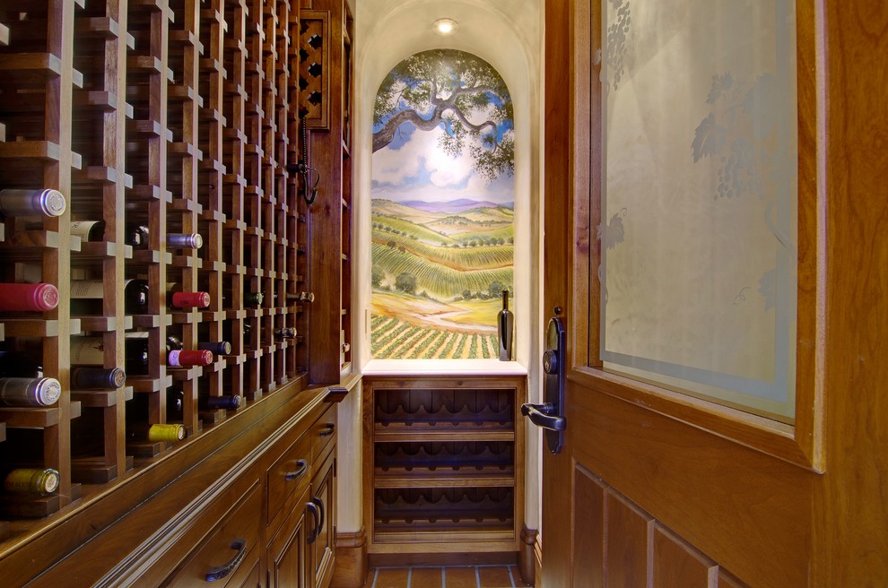 Inspiration för en stor medelhavsstil vinkällare, med klinkergolv i terrakotta och vinhyllor
