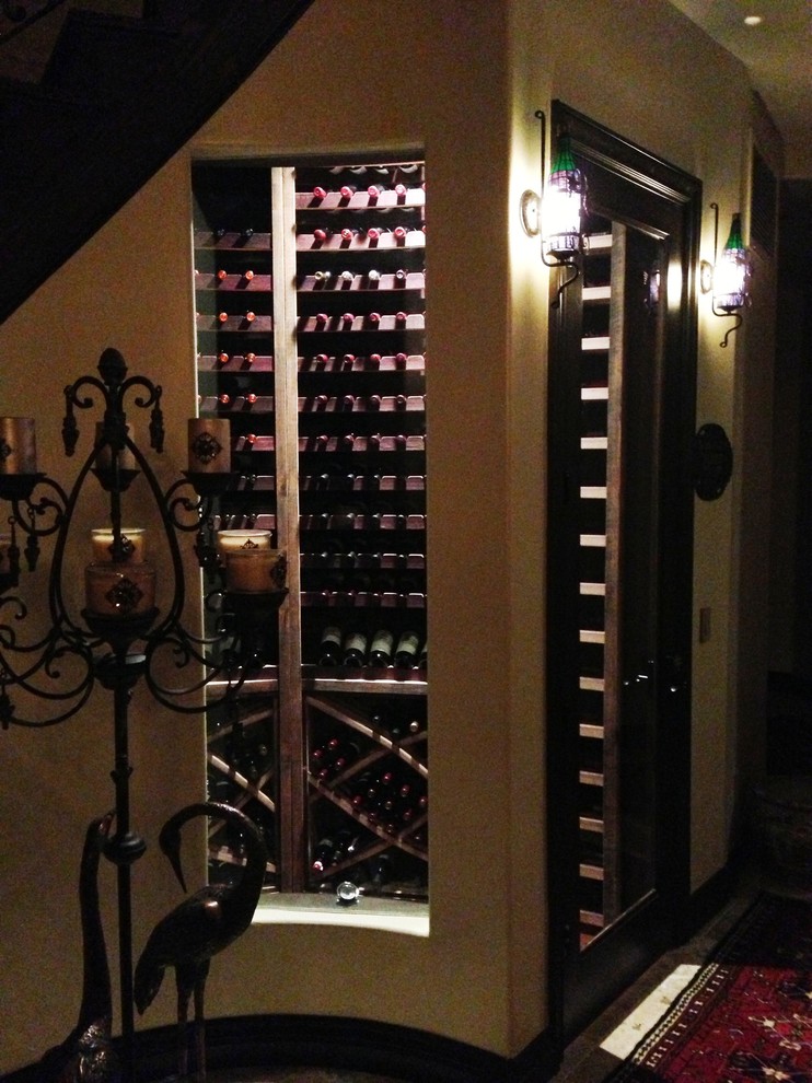 Réalisation d'une petite cave à vin design avec sol en béton ciré et des casiers.
