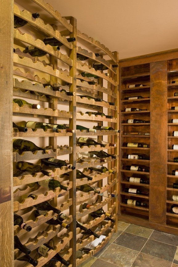 Réalisation d'une cave à vin tradition de taille moyenne avec des casiers.