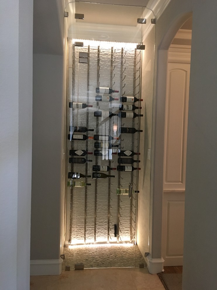 This is an example of a small modern wine cellar in Dallas with storage racks.