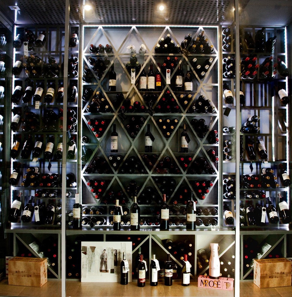 Bild på en stor funkis vinkällare, med vinställ med diagonal vinförvaring