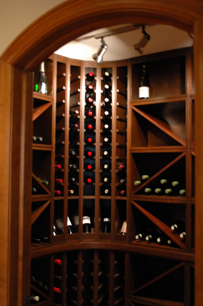 Exemple d'une cave à vin craftsman de taille moyenne avec un sol en bois brun et des casiers losange.