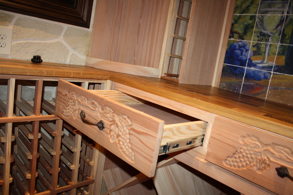 Immagine di una piccola cantina classica con pavimento in legno massello medio e portabottiglie a scomparti romboidali