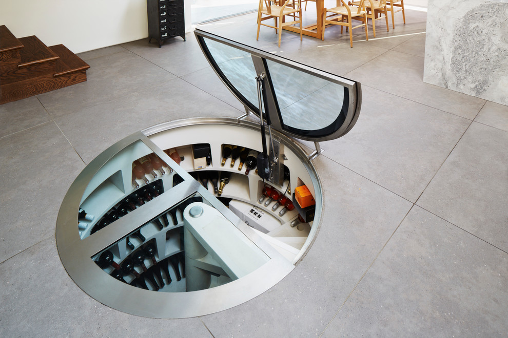 Small contemporary wine cellar in London with storage racks.
