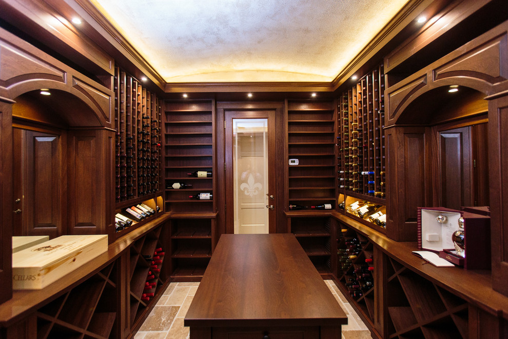 Diseño de bodega clásica, grande, con suelo de travertino y botelleros