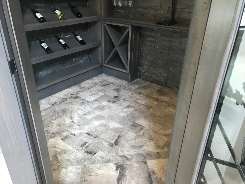 Modern inredning av en liten vinkällare, med marmorgolv, vinhyllor och grått golv