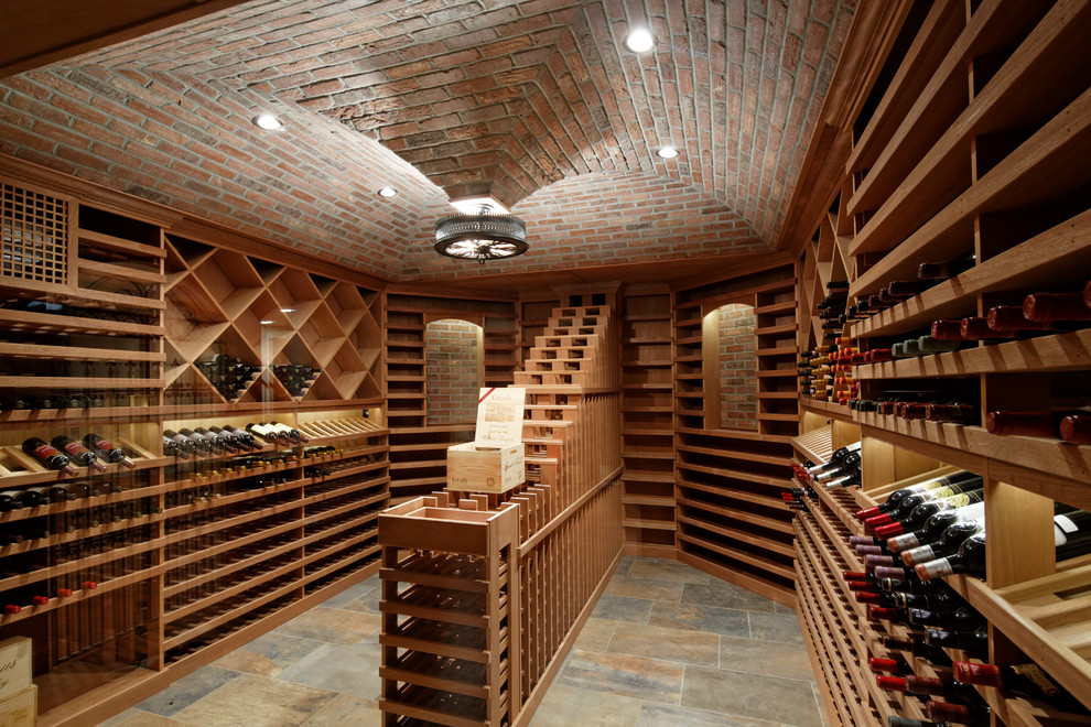 Inredning av en klassisk stor vinkällare, med vinställ med diagonal vinförvaring, skiffergolv och grått golv