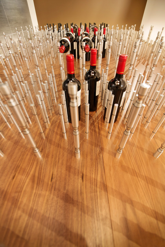Imagen de bodega contemporánea grande con suelo de baldosas de porcelana y botelleros