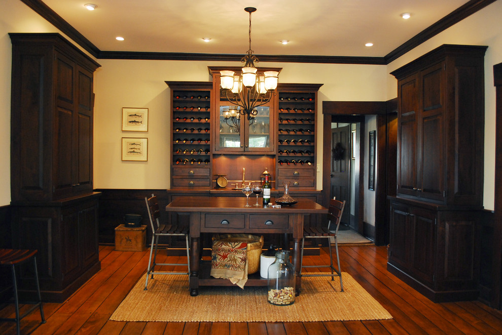 Medium sized classic wine cellar in Columbus with dark hardwood flooring, storage racks and orange floors.