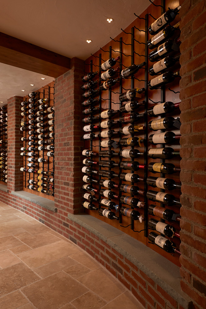 Design ideas for a traditional wine cellar in Boston with storage racks and beige floors.