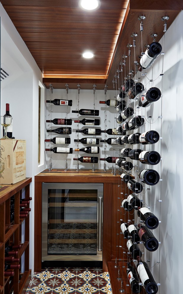 Esempio di una piccola cantina mediterranea con rastrelliere portabottiglie, pavimento multicolore e pavimento con piastrelle in ceramica