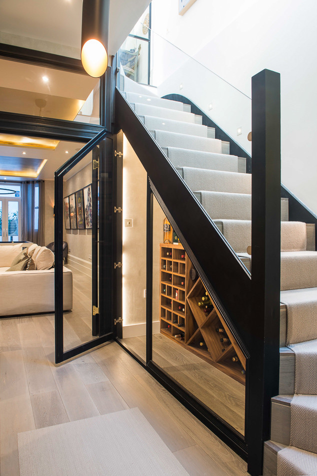 Inspiration for a medium sized contemporary wine cellar in London with medium hardwood flooring, display racks and brown floors.