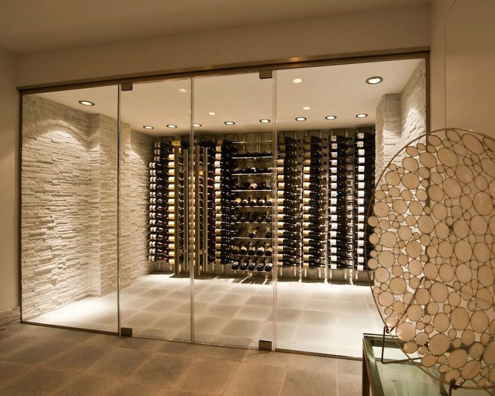 Cette image montre une cave à vin design de taille moyenne avec sol en béton ciré, un présentoir et un sol gris.