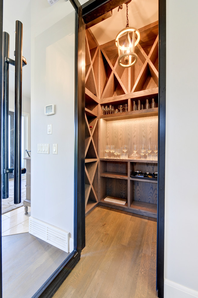 Wine cellar - small contemporary medium tone wood floor and brown floor wine cellar idea in Calgary with diamond bins