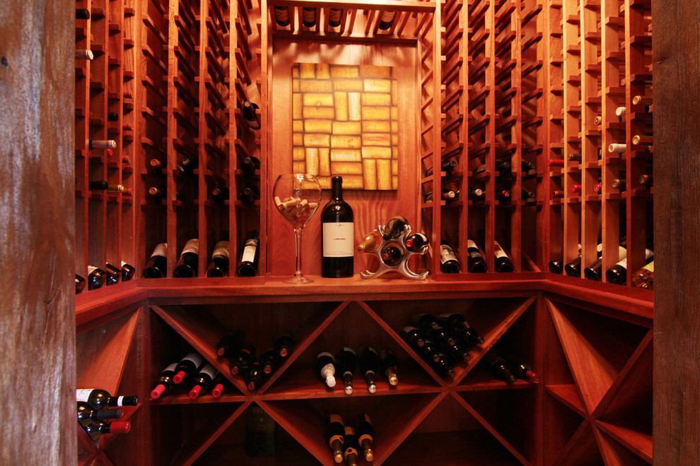 Foto på en mellanstor medelhavsstil vinkällare, med mörkt trägolv och vinhyllor