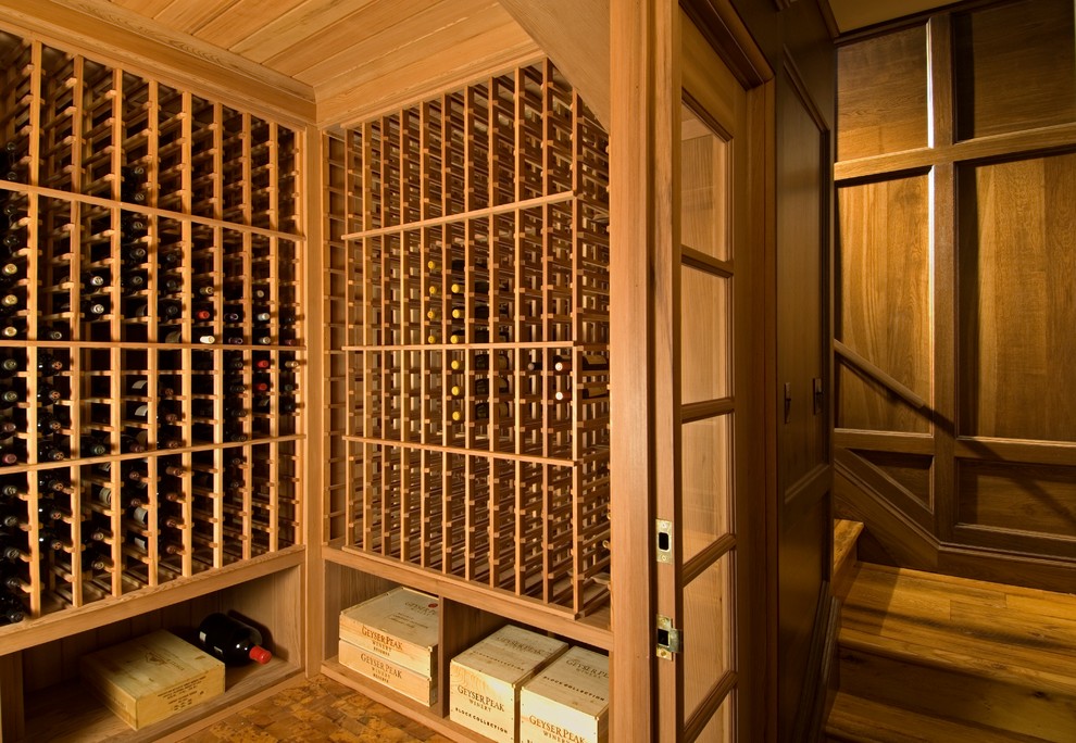 Idée de décoration pour une cave à vin tradition avec un sol en bois brun et des casiers.