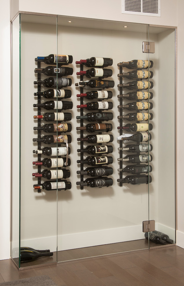 This is an example of a small contemporary wine cellar in Seattle with medium hardwood flooring, display racks and grey floors.