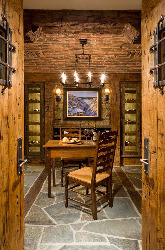 Photo of a rustic wine cellar in Other with storage racks and grey floors.