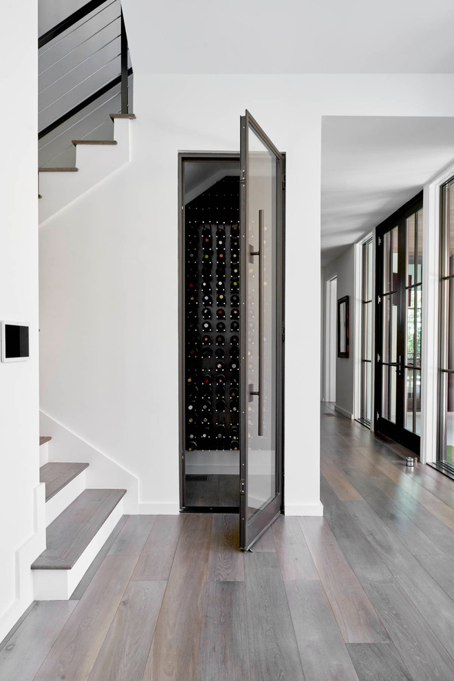 Design ideas for a small contemporary wine cellar in Dallas with dark hardwood flooring, storage racks and brown floors.