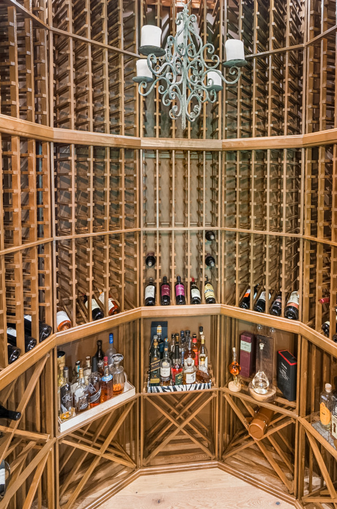 Cette photo montre une grande cave à vin avec parquet clair et des casiers losange.