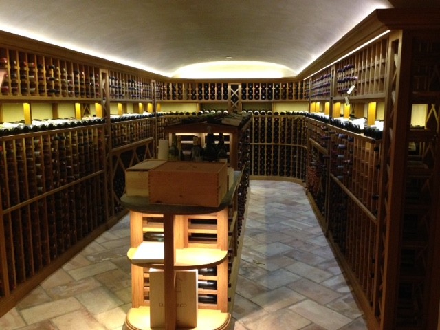 Idée de décoration pour une très grande cave à vin chalet avec tomettes au sol et des casiers.
