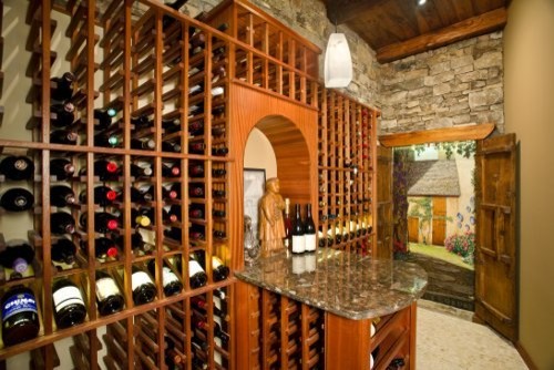 Cette image montre une cave à vin chalet de taille moyenne avec un sol en travertin et des casiers.