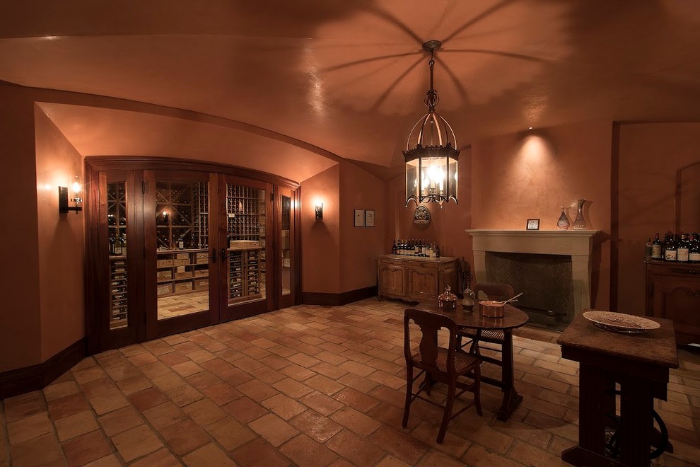 Idée de décoration pour une cave à vin tradition de taille moyenne avec tomettes au sol et des casiers losange.