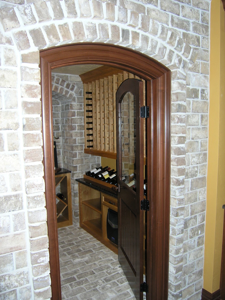 Пример оригинального дизайна: винный погреб среднего размера в классическом стиле с кирпичным полом, стеллажами и серым полом