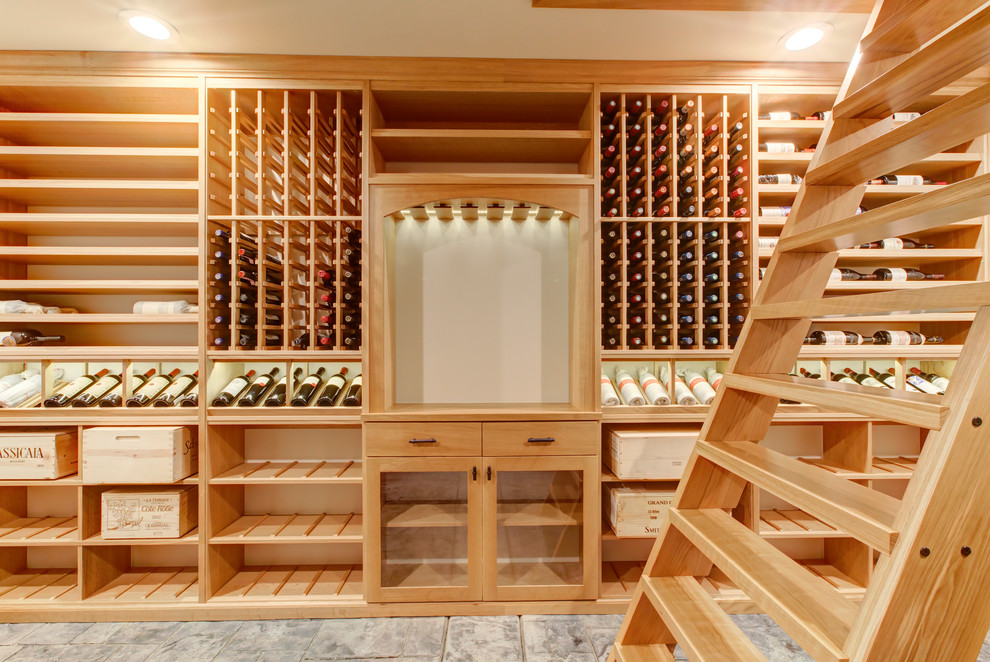 Cette image montre une cave à vin traditionnelle de taille moyenne avec sol en béton ciré, un présentoir et un sol gris.