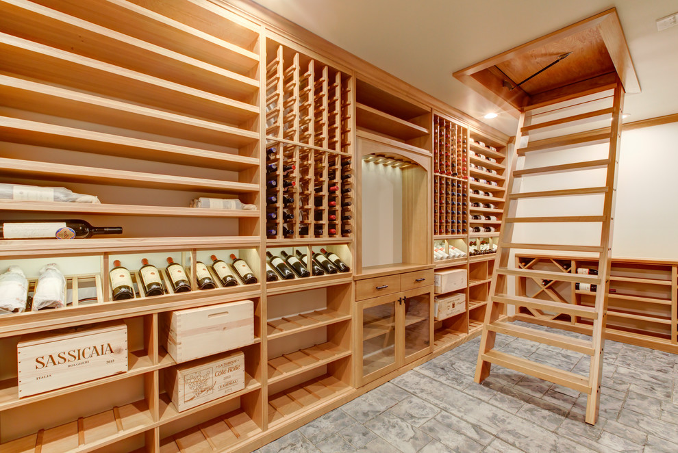Wine cellar - mid-sized transitional concrete floor and gray floor wine cellar idea in Raleigh with display racks