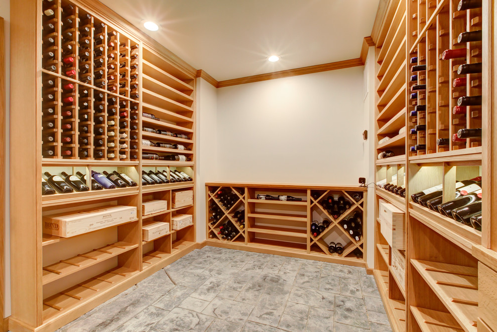 Aménagement d'une cave à vin classique de taille moyenne avec sol en béton ciré, un présentoir et un sol gris.