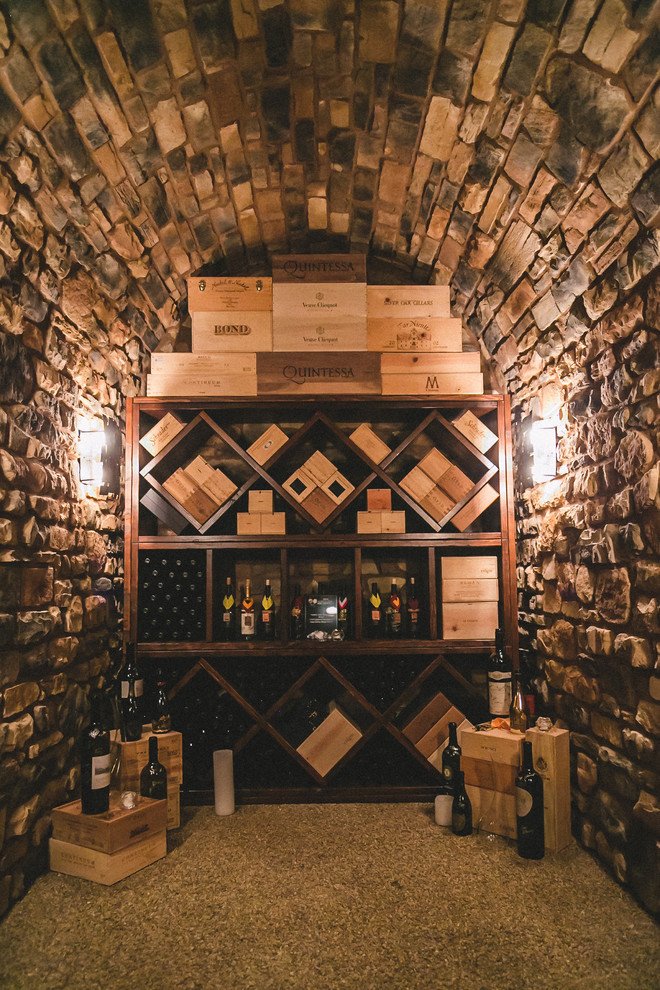 Bild på en medelhavsstil vinkällare, med vinställ med diagonal vinförvaring och grått golv