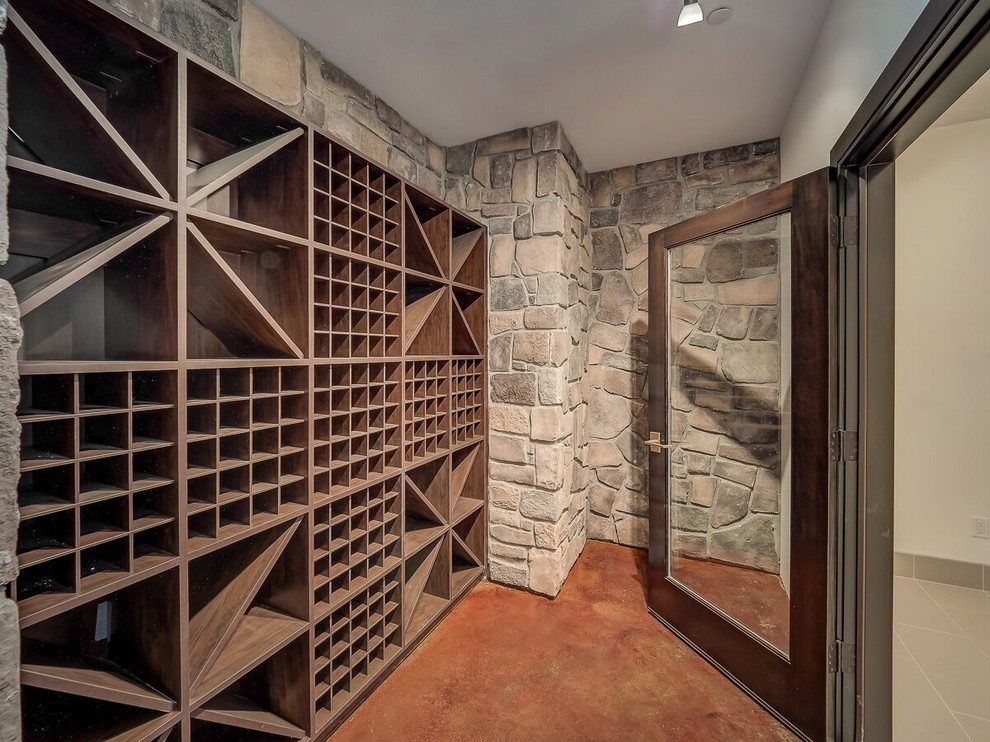 Cette image montre une cave à vin minimaliste de taille moyenne avec des casiers et un sol marron.