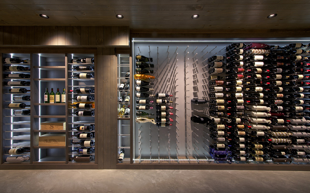 Inspiration for a large industrial concrete floor wine cellar remodel in Los Angeles with display racks