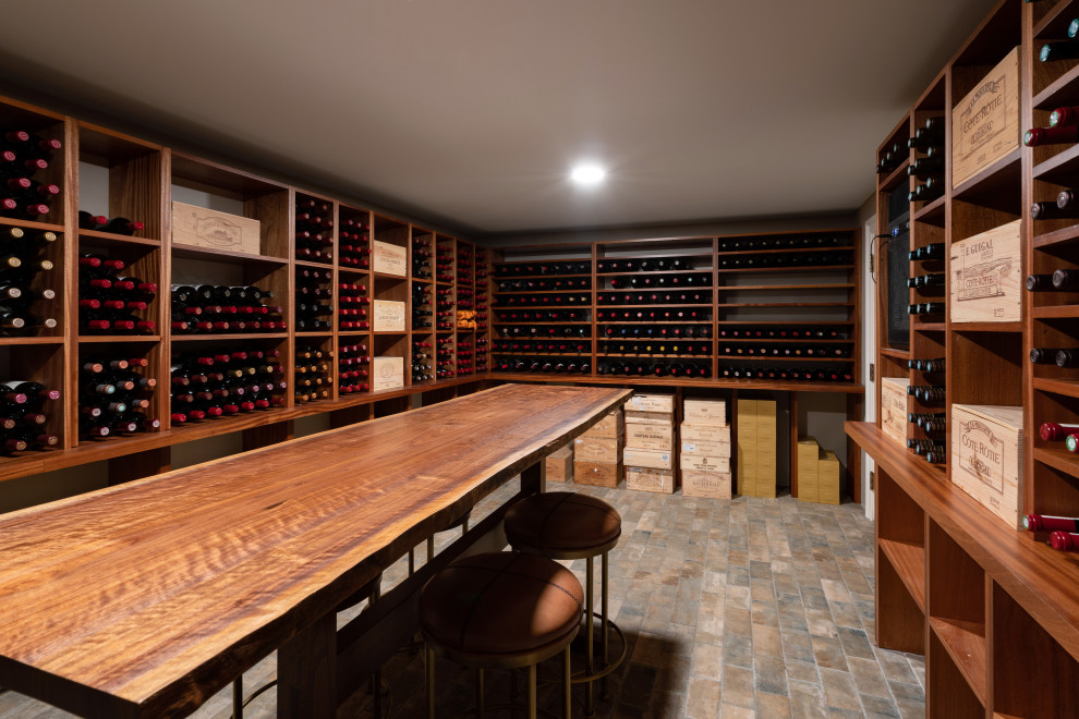 Idée de décoration pour une grande cave à vin tradition avec un sol en brique, des casiers et un sol marron.