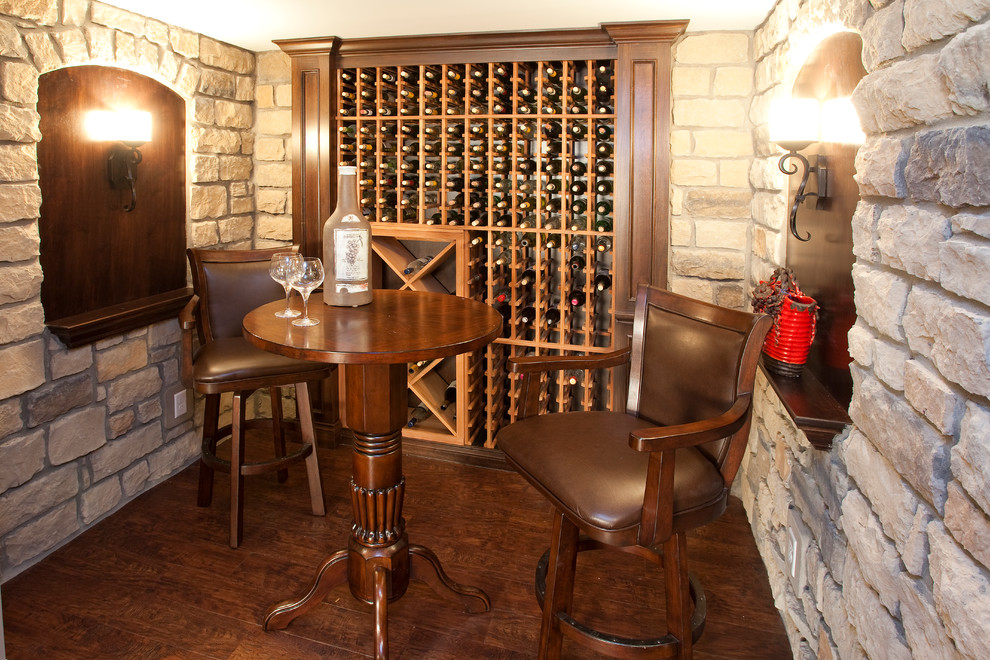 Photo of a small traditional wine cellar in Cincinnati with dark hardwood flooring and storage racks.