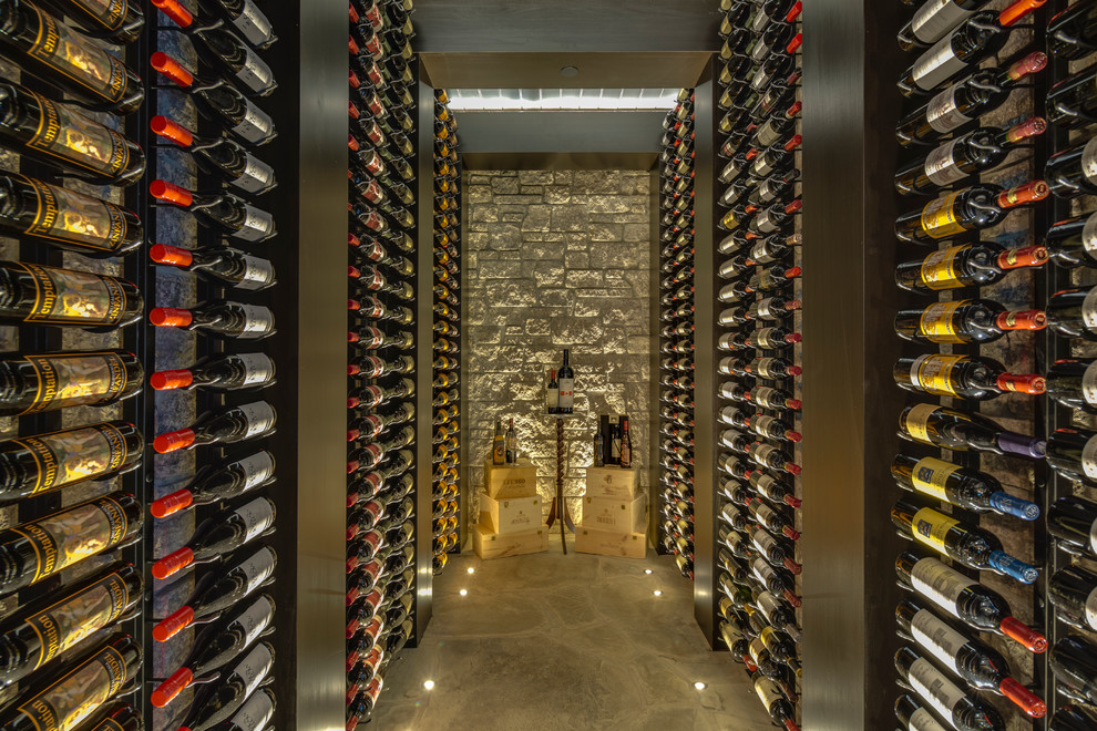 Aménagement d'une cave à vin contemporaine avec des casiers et un sol gris.