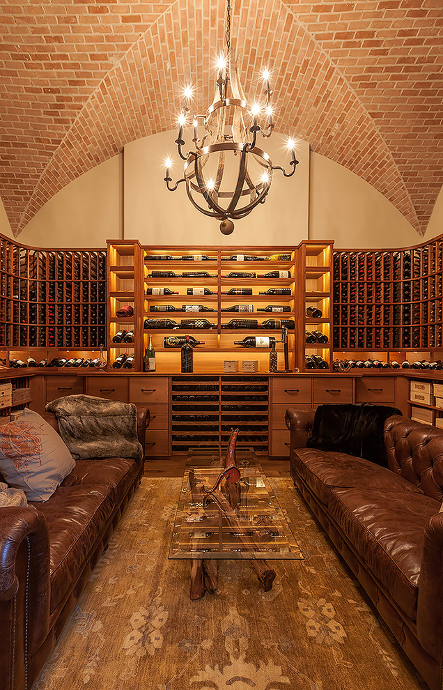 Inspiration pour une très grande cave à vin avec un sol en bois brun et des casiers.