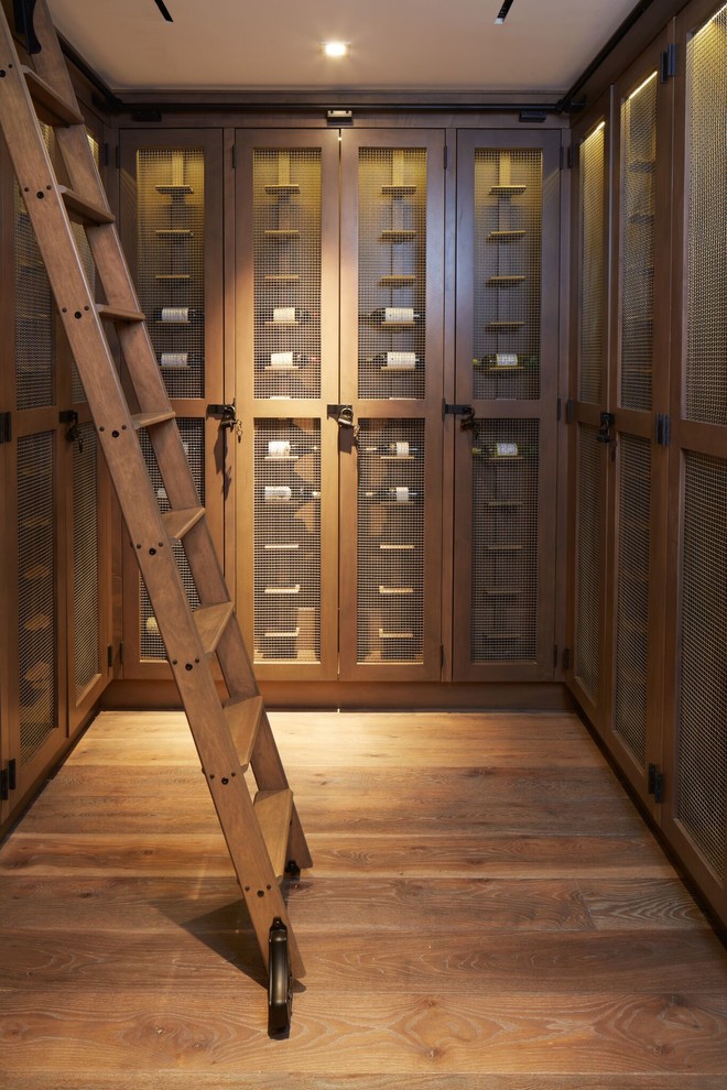 Wine cellar - coastal medium tone wood floor and brown floor wine cellar idea in Other with display racks