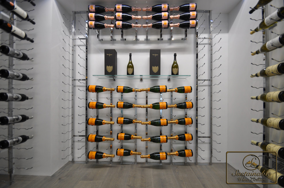 Cette image montre une cave à vin design de taille moyenne avec un sol en bois brun et un présentoir.