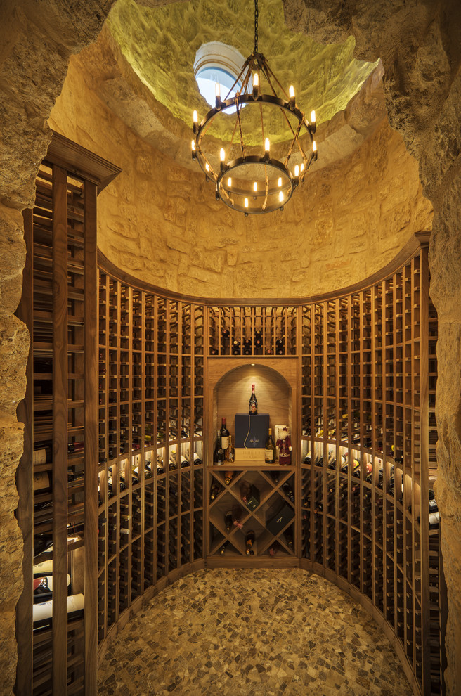 Réalisation d'une cave à vin méditerranéenne avec des casiers et un sol gris.