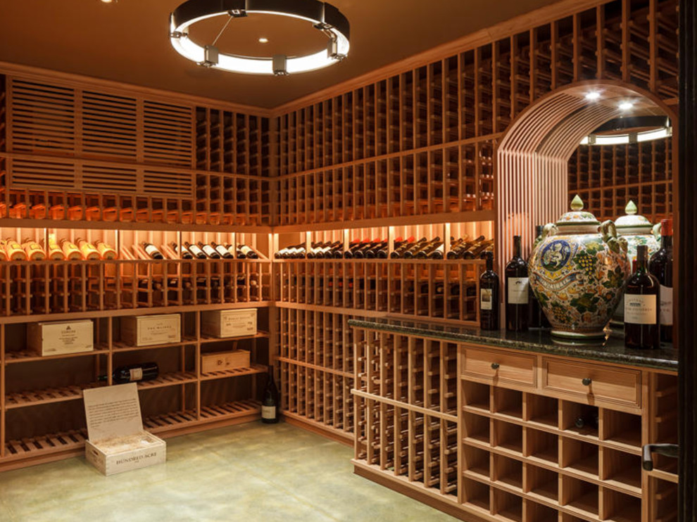 Cette photo montre une cave à vin chic de taille moyenne avec sol en béton ciré, des casiers et un sol gris.