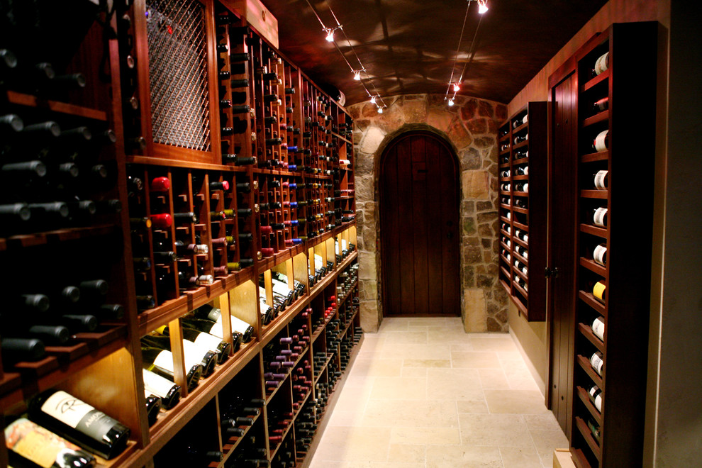 Bild på en mellanstor vintage vinkällare, med travertin golv, vinhyllor och beiget golv