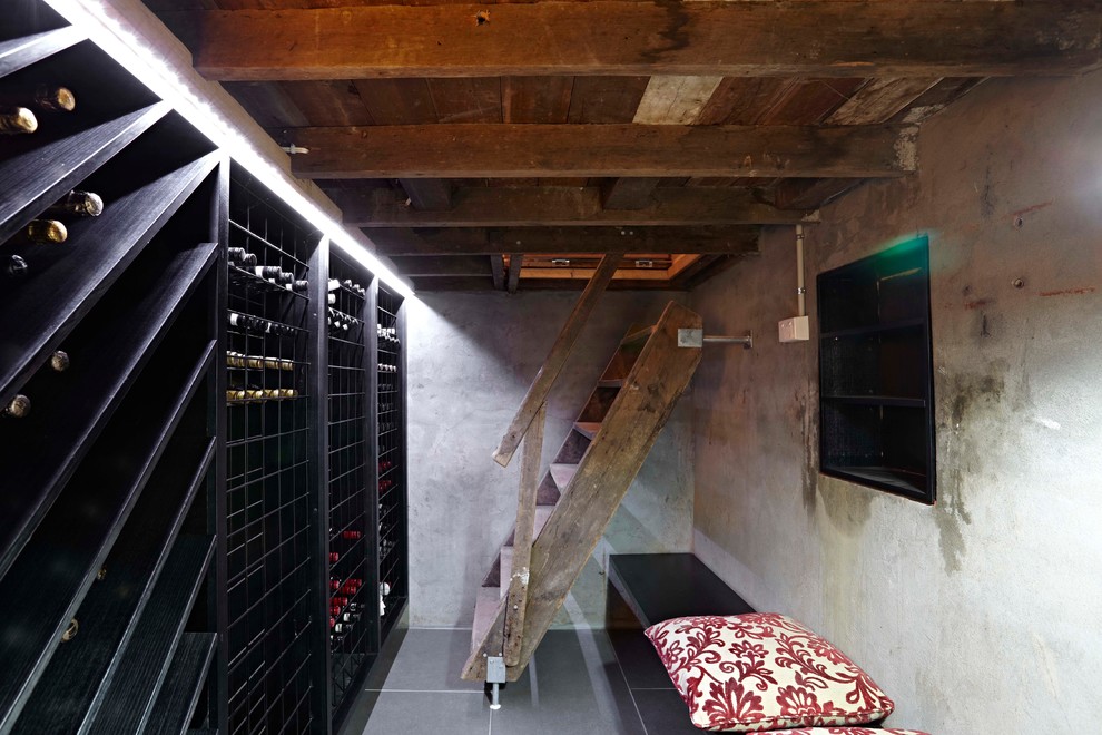 Immagine di una cantina design di medie dimensioni con rastrelliere portabottiglie e pavimento grigio